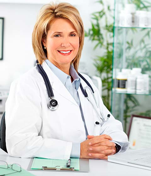 женщина врач улыбается и смотрит в камеру